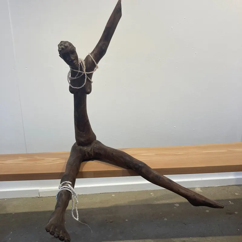 Slender carved figure in a wide stance
