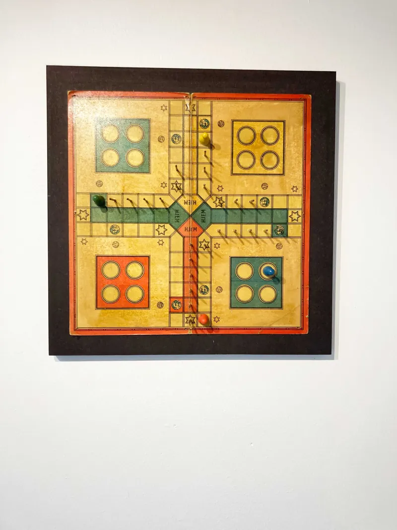 An old Ludo board framed in dark wood