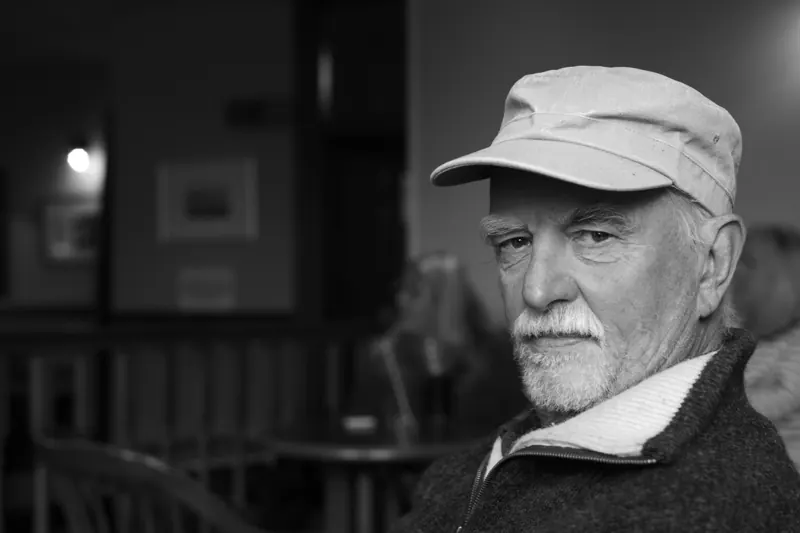 Black and white portrait of Jeremy Cosmo Davies in a cap