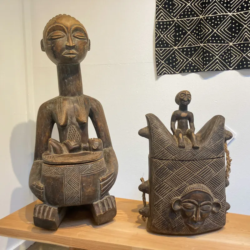 Carved seated figure and a lidded wooden vessel