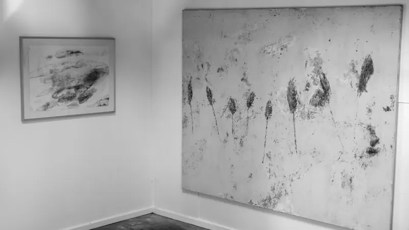 Large work on paper of scattered marks, beside a small framed print