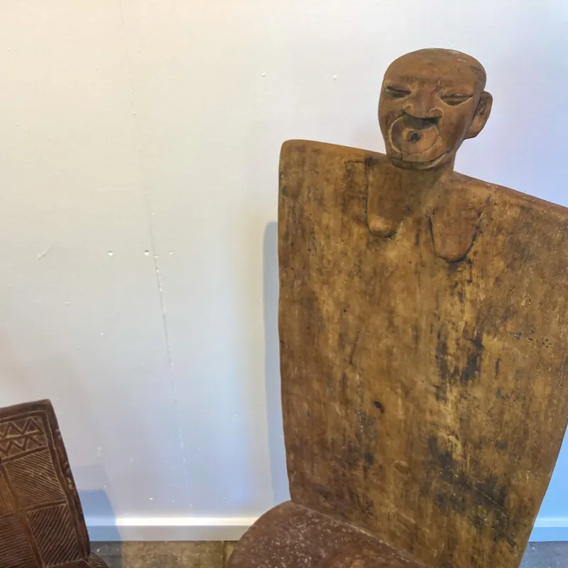 Carved figure rising from a wooden board