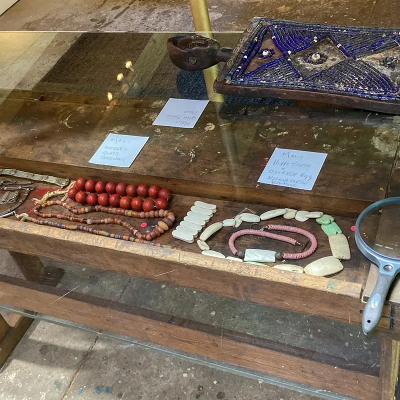 Display case of beads and a painted panel