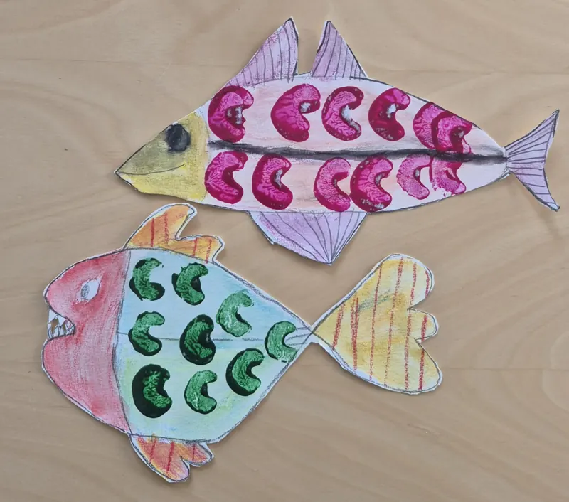 Two painted paper fish with patterned scales