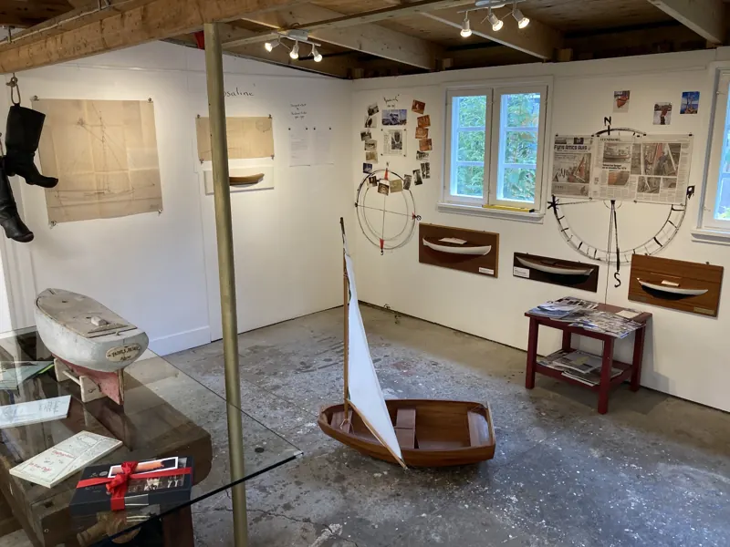 Gallery interior with boat models, a small sailing dinghy and drawings on the walls