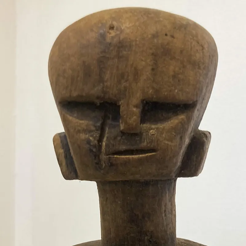 Carved wooden head with a broad flat crown