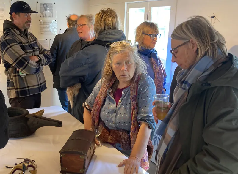 Islanders gathered around a table of objects at the opening