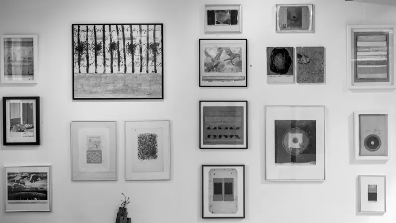 A wall of small framed black and white works